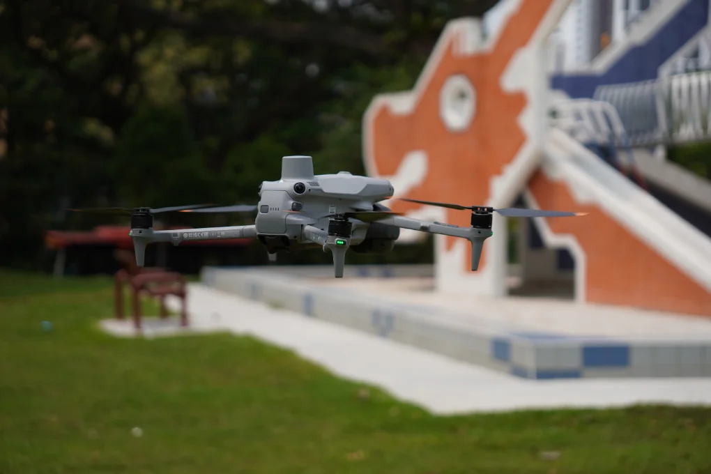 CAAS-licensed Pitch Perfect Systems drone pilot in hi-vis on a Singapore site